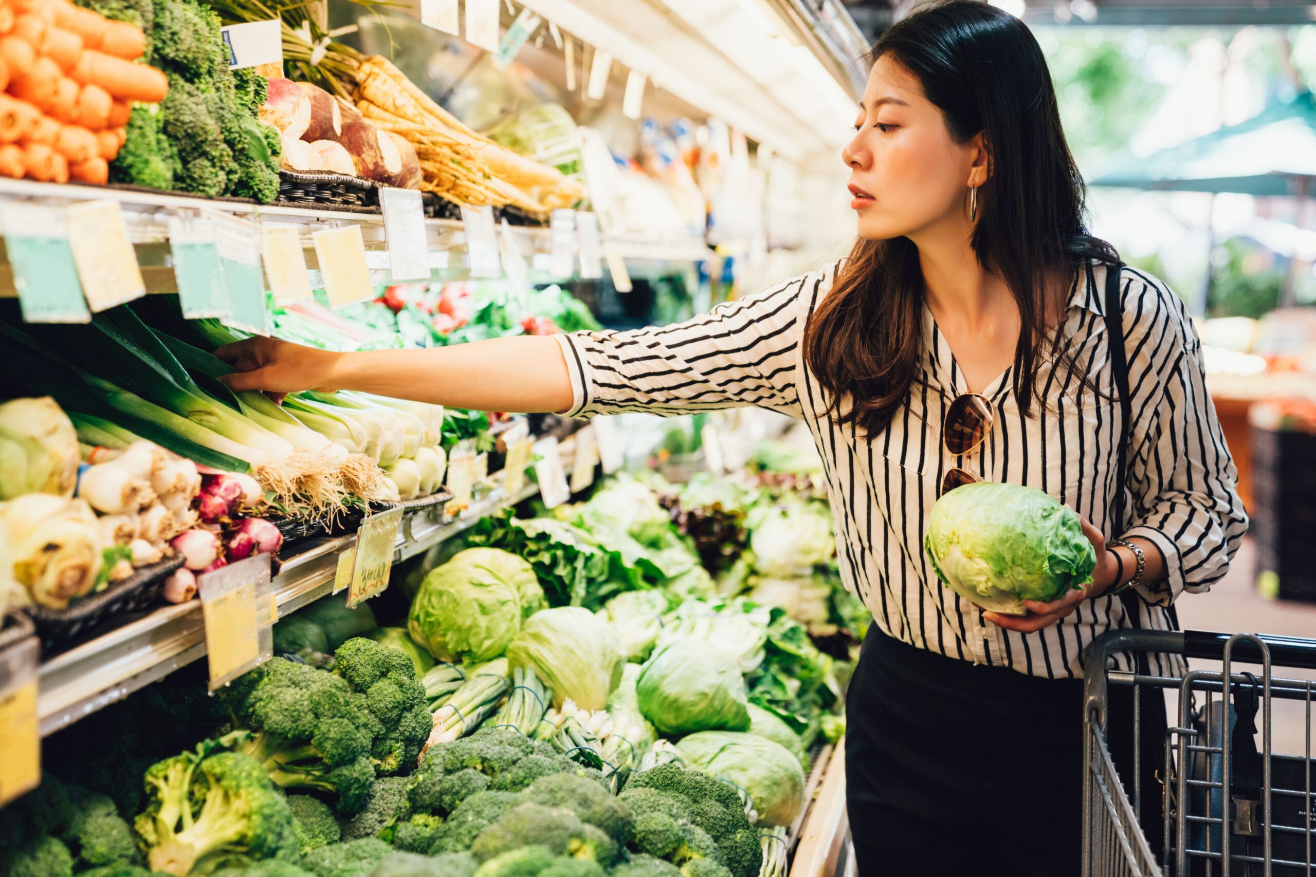 woman selecting produce in supermarket scaled